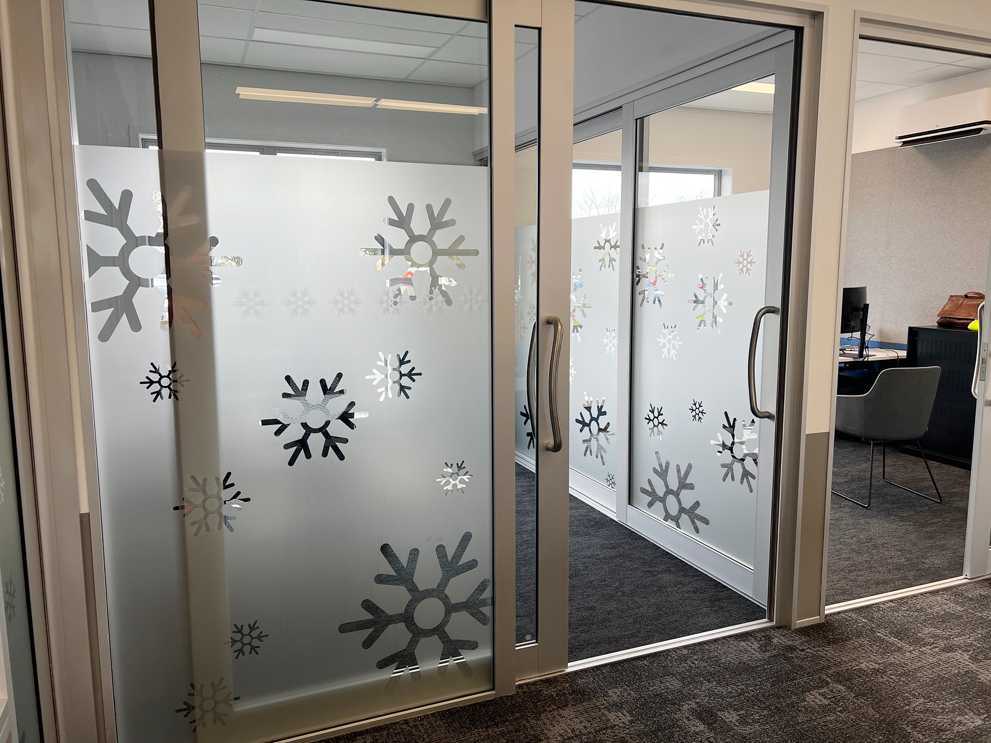 Hall’s snowflake window manifestations across internal office glass